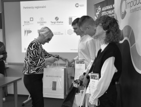 pracownik urzędu wręcza upominki uczestnikom olimpiady