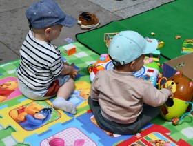 małe dzieci bawiące się zabawkami na kocyku