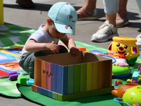 mały chłopiec zaglądający do kolorowego pudełka